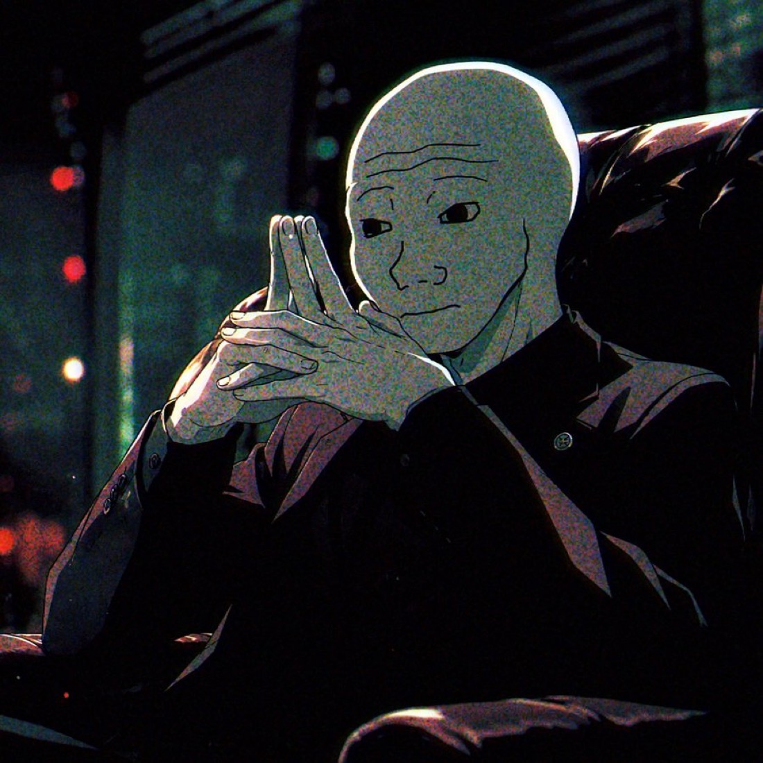 Anijak sitting in a dark room with city lights behind him